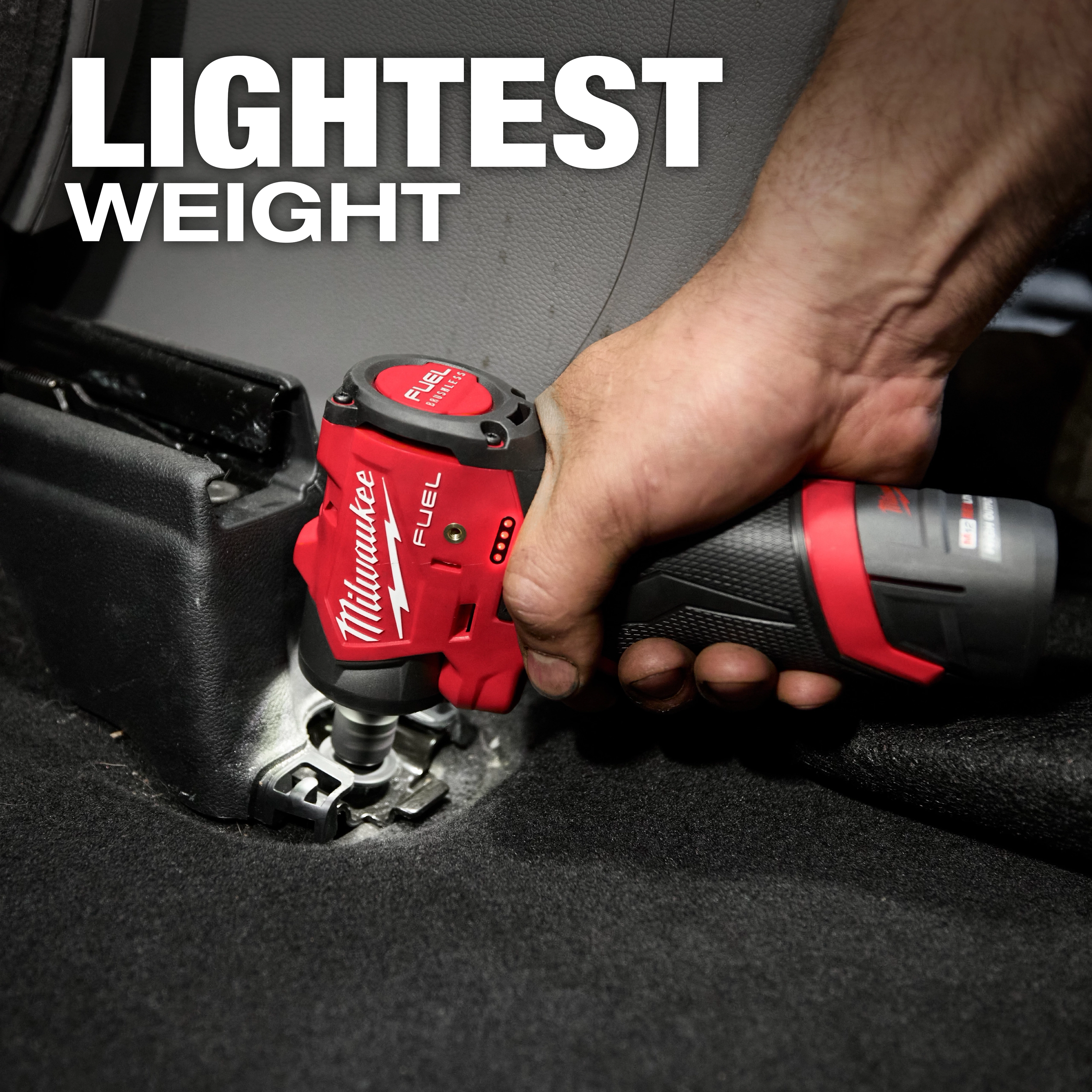 A person uses the Milwaukee M12 FUEL™ 1/4" Subcompact Impact Wrench w/ Friction Ring to tighten a bolt in a car interior. The text "LIGHTEST WEIGHT" is displayed above the tool.