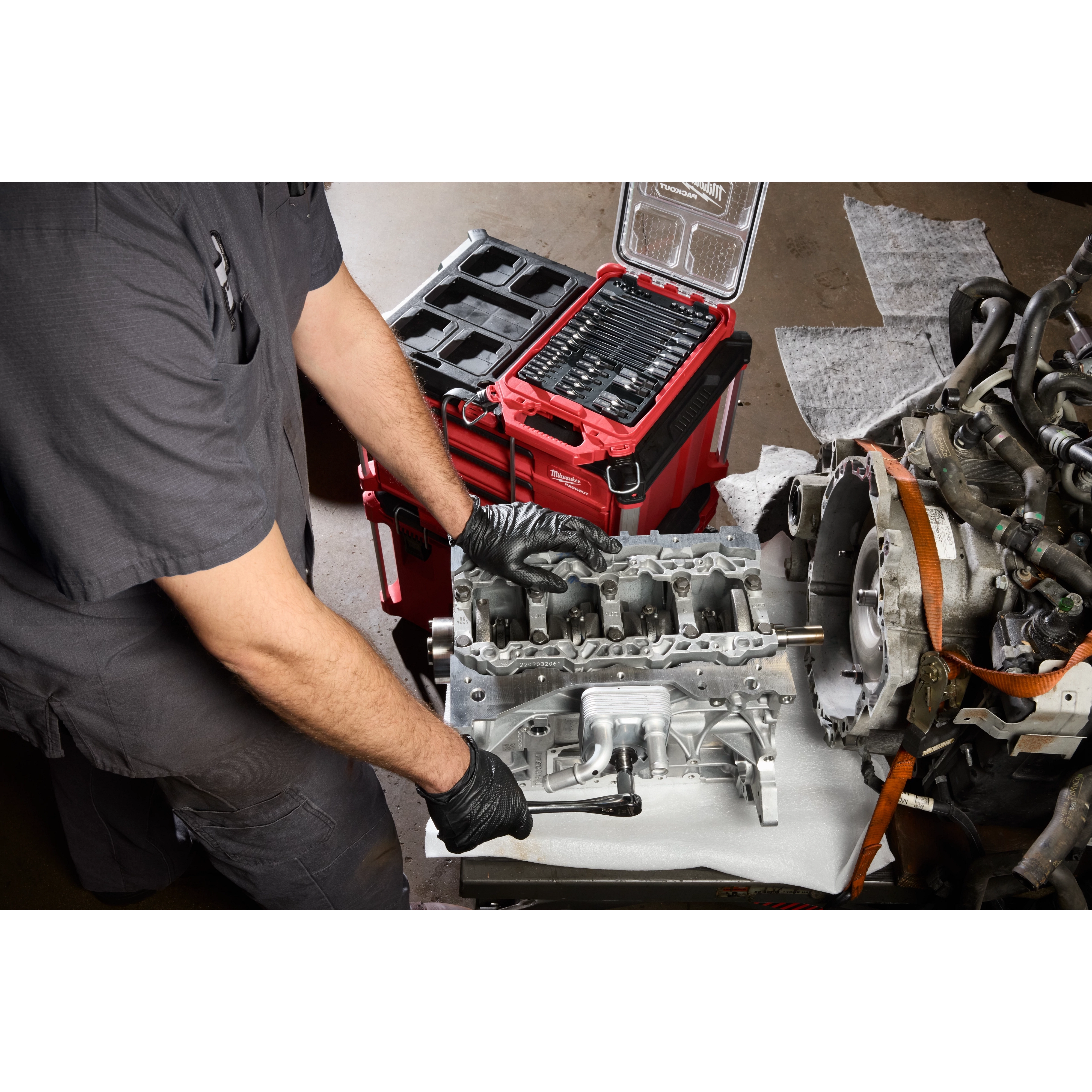 Mechanic using the 41pc 1/4” and 3/8” Drive Metric Bit Socket Set with PACKOUT Compact Low-Profile Organizer on an engine.