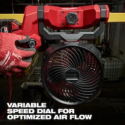 M18 Brushless Scissor Lift Fan with a variable speed dial for optimized airflow, handled by a person wearing red gloves.