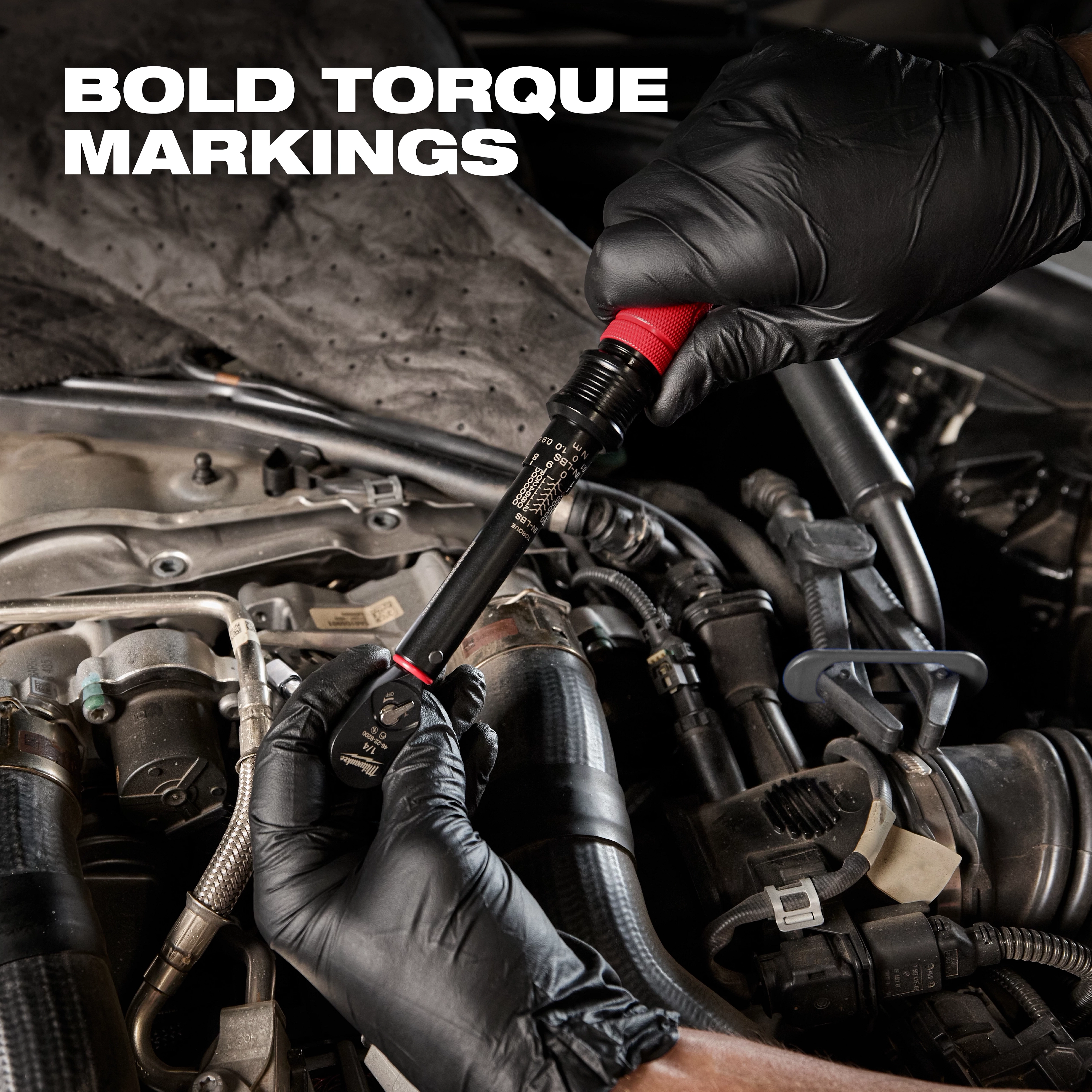 Person wearing black gloves uses the 1/4” Drive Click Torque Wrench (40-200 in·lbf) to adjust a part in a car's engine bay.