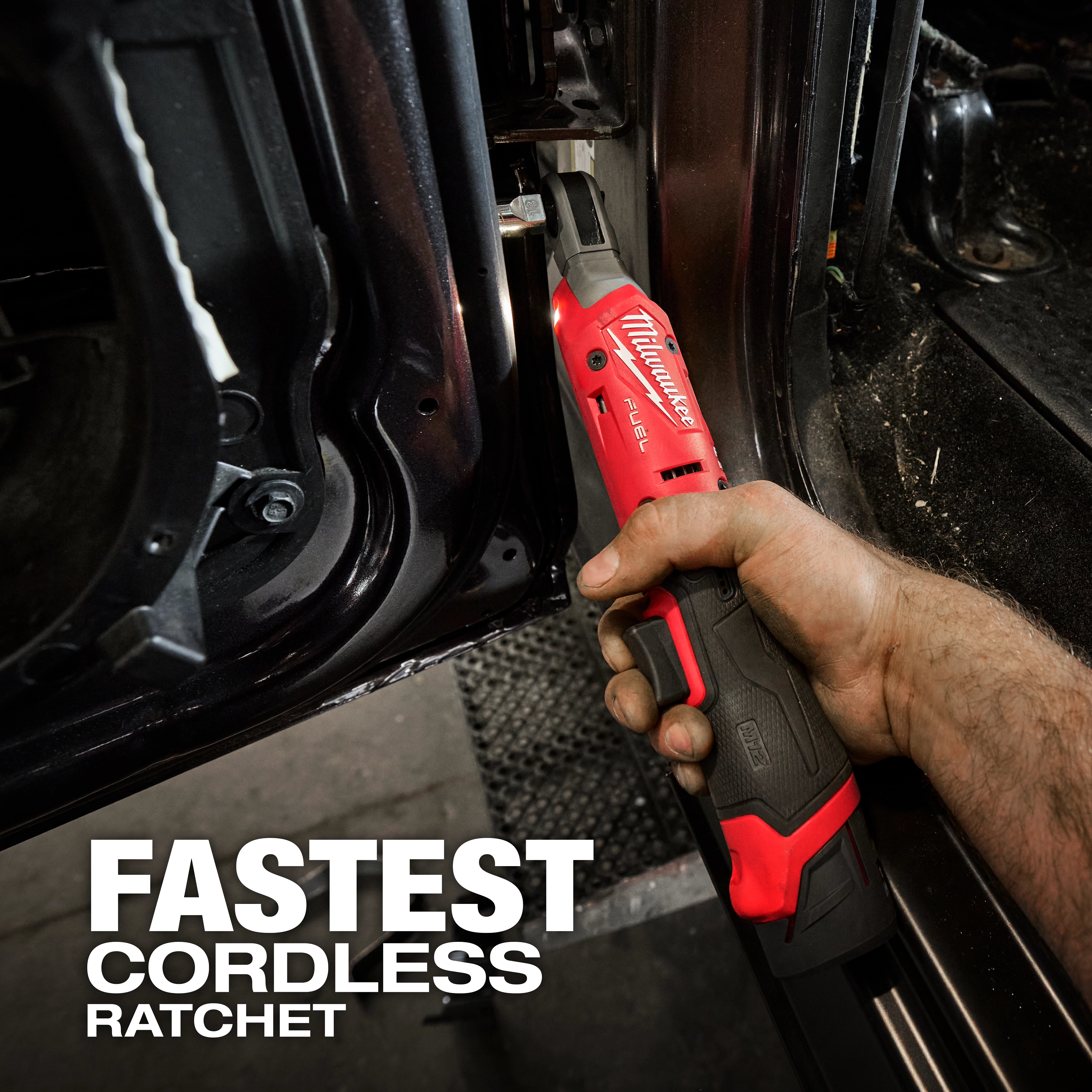 A person uses the M12 FUEL™ 1/4" Ratchet to work on a vehicle door frame. "Fastest Cordless Ratchet" is written in large text at the bottom left. The tool is red with the brand and model name prominently visible.