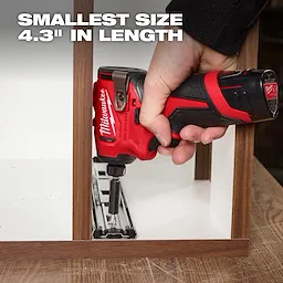 A hand uses a red and black Milwaukee cordless power tool to screw a metal piece onto a wooden frame. The text "SMALLEST SIZE 4.3'' IN LENGTH" is displayed in the upper left corner of the image.