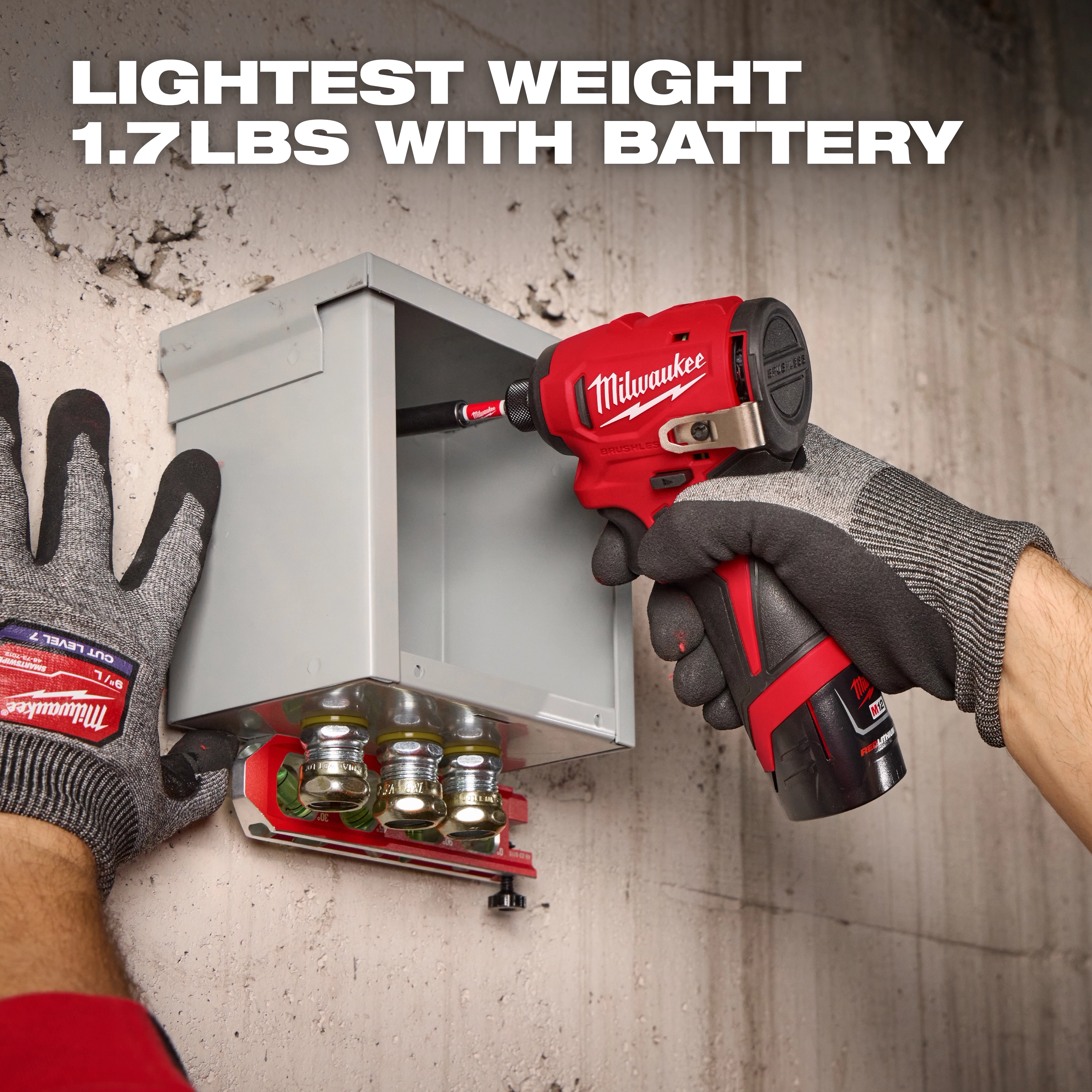 A person wearing Milwaukee gloves uses a Milwaukee cordless screwdriver to work on an electrical box mounted on a concrete wall. Text at the top reads, "LIGHTEST WEIGHT 1.7LBS WITH BATTERY."