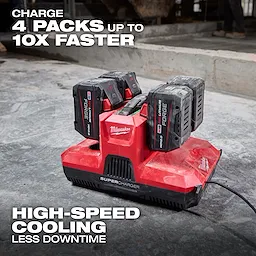 M18 & M12 Four Bay Simultaneous Super Charger w/ PACKOUT Compatibility charging four batteries on a concrete floor.