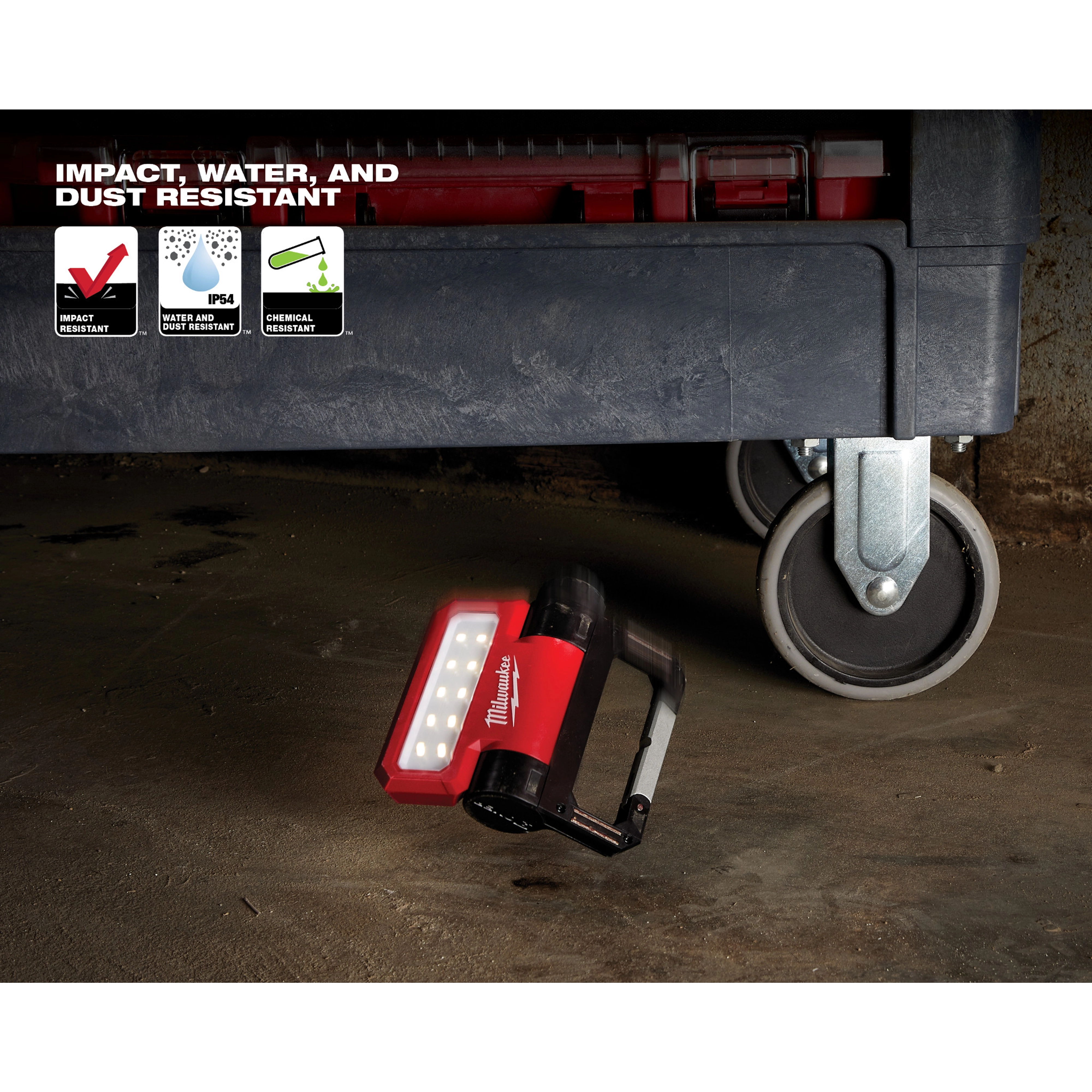 REDLITHIUM USB ROVER Pivoting Flood Light is shown under a tool cart, highlighting its impact, water, and chemical resistance.