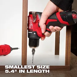 A hand grips a red and black Milwaukee cordless drill with a drill bit attached. "Smallest size 5.4" in length" is written at the bottom. Another red drill lies in the background.