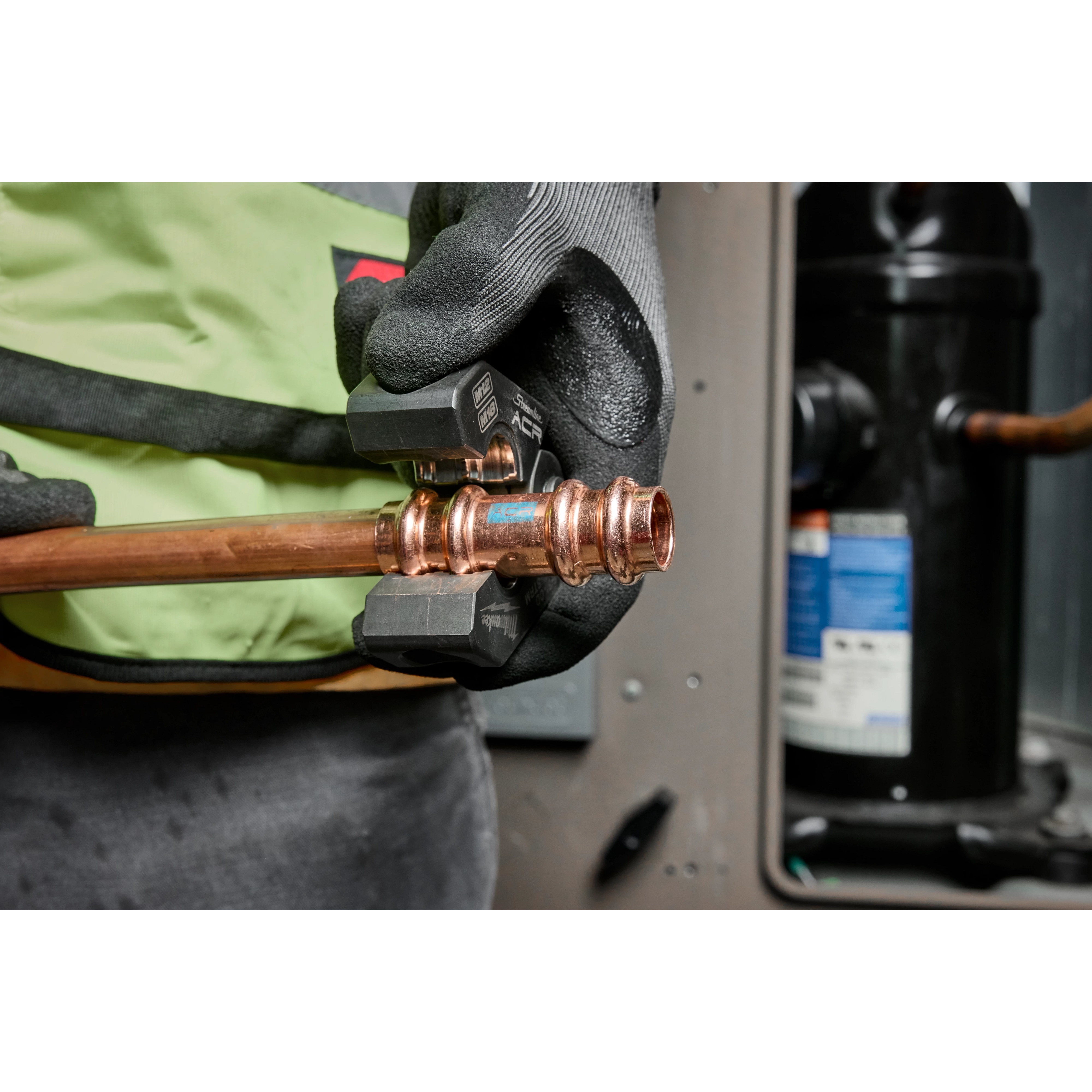 The 1/4" - 7/8" Streamline® ACR Pivoting Press Ring Kit is shown being used with the M18™ FORCE LOGIC™ press tool on a copper pipe. The image depicts a close-up of hands wearing gloves, pressing a fitting onto the pipe in an industrial environment.
