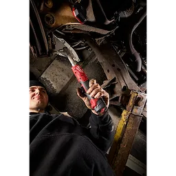 Person using an M12 FUEL 3/8" Extended Reach Ratchet on vehicle undercarriage.